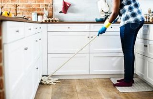 picture of woman cleaning kitchen floor of spiders